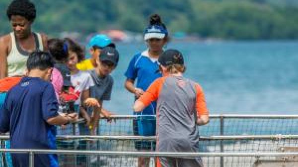 Group of students with teacher at an aquaculture facility.