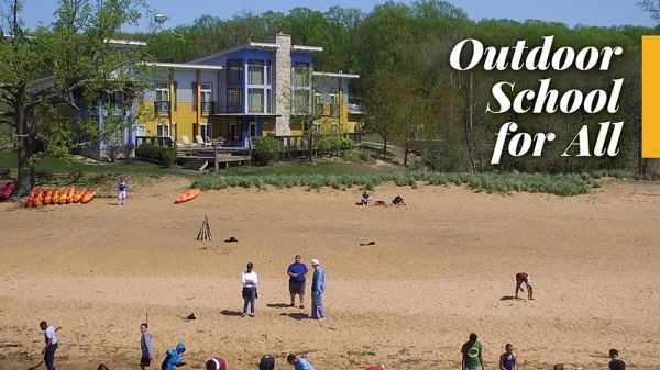 A magazine cover: the top reads in large text, "Directions." A photo of a group of people on a beach, lined up along the water. In the background, a building stands among trees, and a blue sky is above.