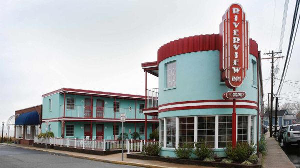 Photo credit: Amanda Maglione @amandamaglionephoto Photo of a blue inn with a retro facade on the corner of a street