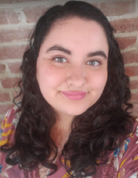 A picture of Annalisse Eclipse  wearing a pink shirt with flowers and smiling