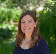 Photo of Eileen Everett with shoulder-length brown hair in a garden type setting