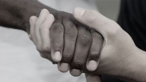 two hands of different skin tones clasping
