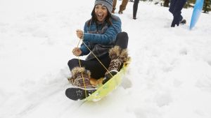 Woman on sled in the snow