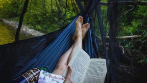 Photo of a woman in a hammock with a book in her hand