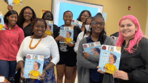 A group of preservice teachers hold up books about bees to promote literacy
