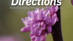 A pink redbud flower emerges from a branch. Above, the text "Directions."
