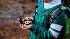 Child holding compass in the woods
