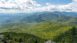 Waves of forest-covered mountains on a semi-cloudy, sunny day