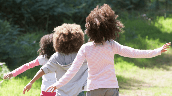 Three young children walking on a nature path