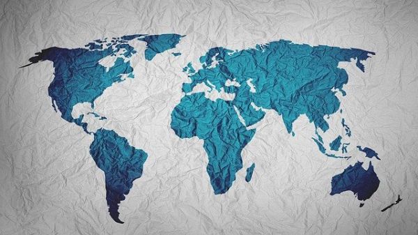 A world map with landforms in blue on wrinkled fabric