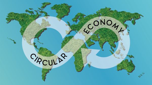 words circular economy in arrow in shape of dollar sign over green map of continents