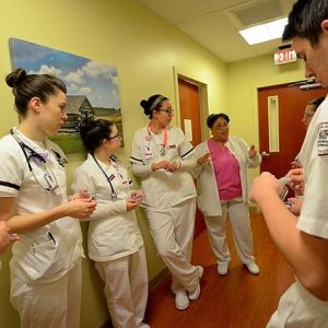 Germanna Community College's Nursing program instructor Phyllis Smith (MSN, RN) (background, center, pink blouse) reviews patient procedure with nursing students at the McGuire V.A. Medical Outpatient Clinic in Fredericksburg, Va. on Tuesday, December 2, 2014. 