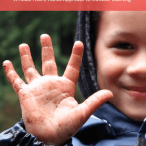 child holding up muddy hand