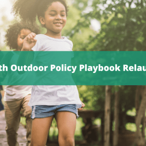 Background photo of three kids running across a wooden path with a green overlay with white text that says, "youth Outdoor Policy Playbook Relaunch. April 18, 3:00 PM ET"