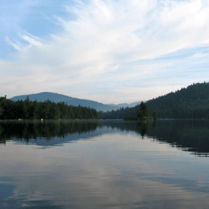 Mountains and a lake under a blue sky with some clouds