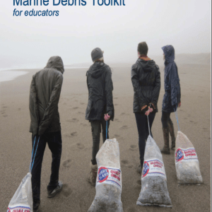 Four people dragging large bags of marine debris across a beach.