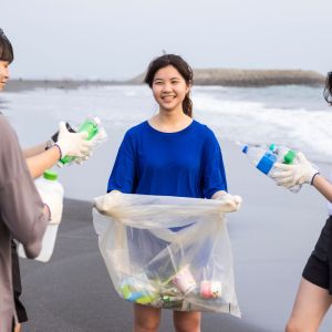 Group of students collect plastic waste on a beach