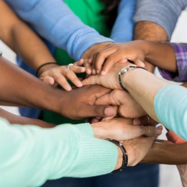 Many hands joined together in a circle. 