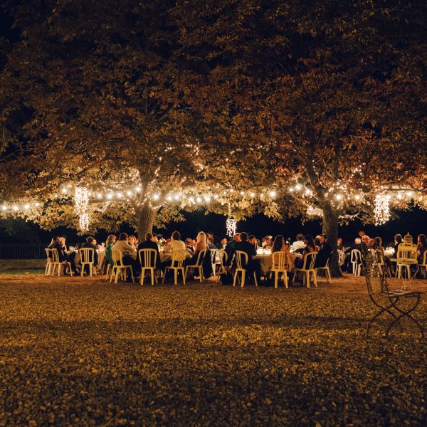 Nighttime outdoor wedding reception with lights