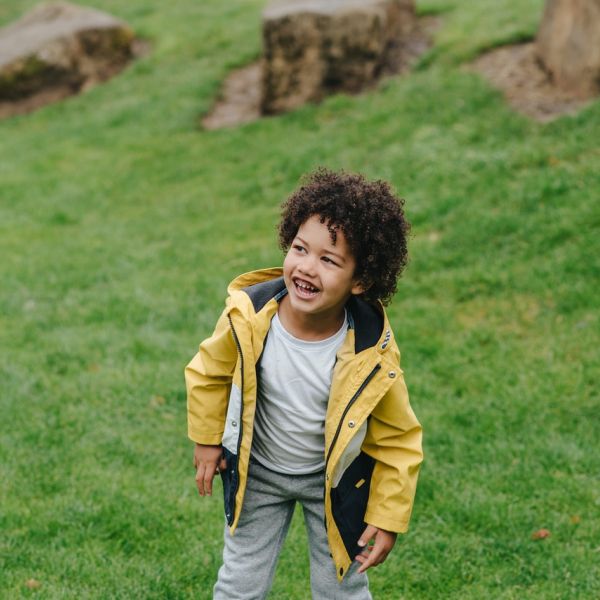 Cheerful black boy on green grass